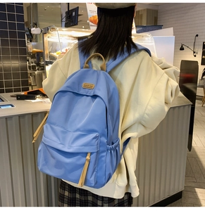 Rear view of a sky blue nylon backpack for students featuring a large capacity
