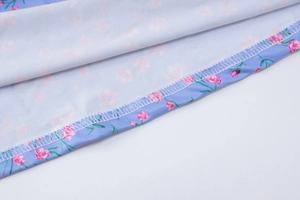 Close-up of floral print fabric showing hem stitching and soft texture detail