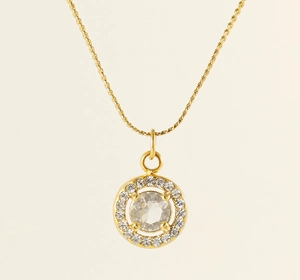 Detailed close-up of a 18K gold-plated necklace featuring a round zircon halo pendant