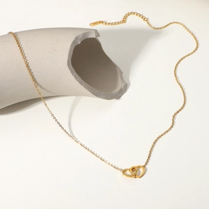 Dettaglio della collana con doppio ciondolo a cuore placcata oro 18K su sfondo bianco