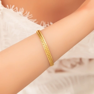 Elegant 18k gold plated stainless steel hollow Cuban chain bracelet on a female wrist