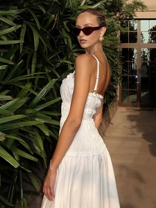Dettaglio dell'abito estivo in cotone bianco con punto smock e spalline a balze