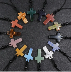 Macro shot of assorted natural crystal cross necklaces with woven cords in various colors