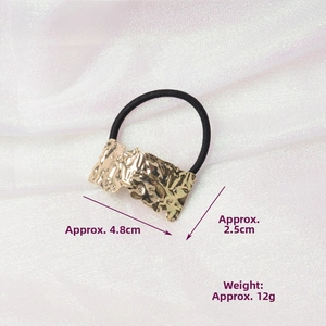 Detail showing irregular gold metal hair tie with dimensions of 4.8cm and 12g weight
