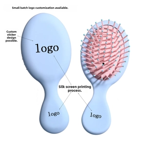 Macro view of portable mini hairbrush with pink air cushion and blue ergonomic handle
