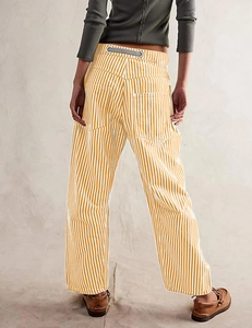 Detail of yellow and white striped wide-leg pants featuring drawstrings and back pockets