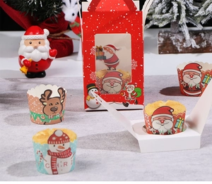 Festliche Weihnachts-Cupcake-Förmchen und rote Geschenkbox mit Weihnachtsmann-Motiven