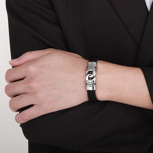 Men's braided leather bracelet with vintage engraved silver buckle on a male wrist
