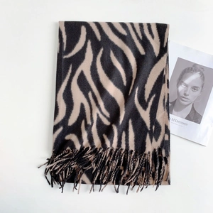 Close-up of black and brown zebra striped winter scarf featuring fringe details and soft texture