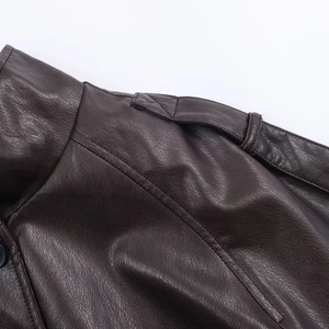 Macro shot of dark brown faux leather jacket collar and shoulder seam details