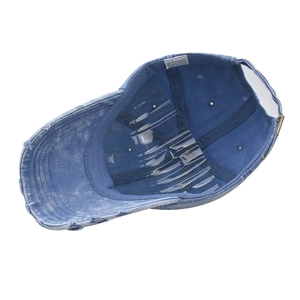 Detail view of the washed cotton denim baseball cap interior showing the 100% cotton label