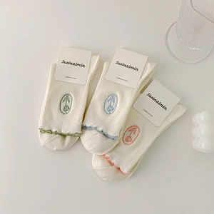 Three pairs of white combed cotton socks with floral embroidery and lettuce trim edges
