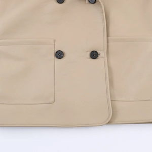 Detail of beige faux shearling jacket showing buttons, stitching and large pocket