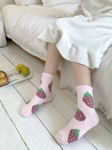 Detailed view of pink coral fleece socks with strawberry pattern for winter warmth