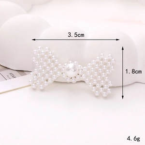 Détail d'un accessoire nœud en perles avec dimensions 3,5cm x 1,8cm sur fond blanc