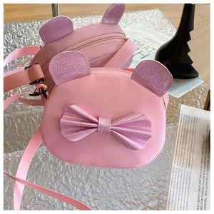 Detail of pink cartoon crossbody bag featuring sparkling bear ears and a large bow tie