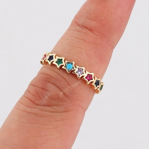 Detailed view of a gold star-shaped ring band set with multi-colored gemstones