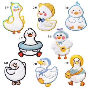 Collection de huit écussons brodés de canards mignons avec divers accessoires sur blanc