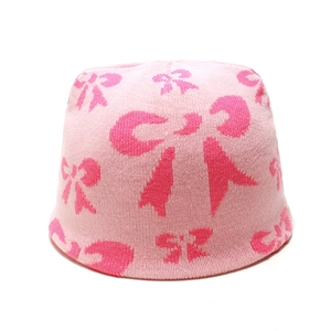 Trama dettagliata del cappello in maglia rosa con motivo a fiocco rosa scuro