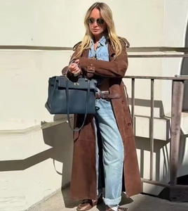 Détail du trench-coat en daim marron avec ceinture nouée et texture mate de qualité