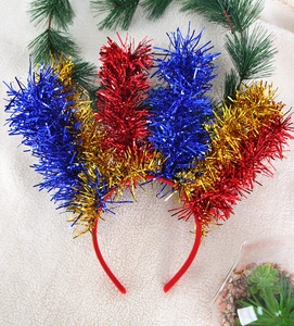 Dettaglio del cerchietto per Carnevale con piume di tinsel rosse, blu e oro lucido