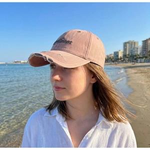 Nahaufnahme einer rosa Vintage-Baseballkappe mit PineCrest-Stickerei und abgenutzten Kanten