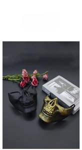 Detailed view of skull half-masks in matte black and bronze finishes for Halloween