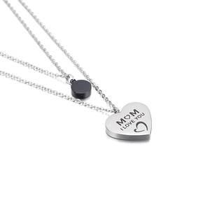 Collana a doppio strato in acciaio argento con ciondolo a cuore inciso MOM su sfondo bianco