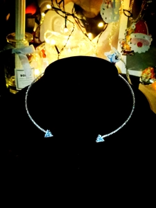 Detailed view of silver choker featuring light blue triangle crystals on a black display
