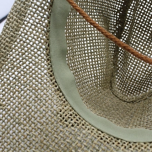 Detail of straw cowboy hat showing hollow weave texture and internal sweatband