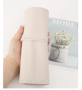 Detail view of the cream white lychee pattern PU leather makeup brush roll with tie closure