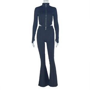 Detail of black slim fit two-piece set featuring cropped zip top and flared high-waist pants
