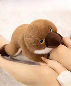 Close-up of plush platypus toy with soft brown fur and sparkling gold glitter eyes