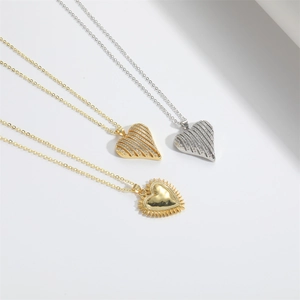 Detailed view of heart-shaped gold and silver pendants with striped and radiating textures