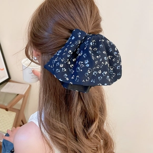 Detail of floral chiffon bow hair scrunchie styled on long brown wavy hair