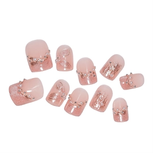 Faux ongles œil de chat rose avec perles, paillettes et détails de ruban doré