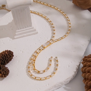 Detailed close-up of gold bamboo-link chain with inlaid rectangular zircon crystals