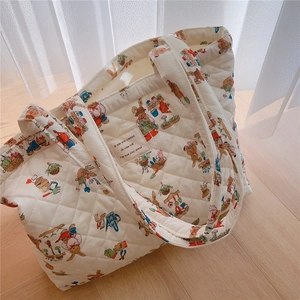 Detailed close-up of quilted tote bag featuring rabbit prints and woven fabric label