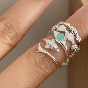 Macro shot of 925 silver ocean series rings featuring dolphin and seashell details