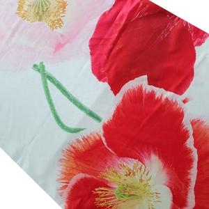 Detailed macro view of red and pink poppy floral print on smooth polyester fabric