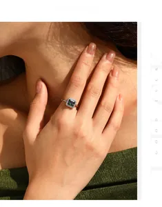 Macro detail of silver halo ring with square colorful gemstone worn on a finger