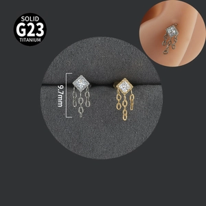 Macro shot of silver and gold G23 titanium labret studs with square zircon and chain