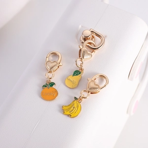 Detail of fruit metal pendants with heart clasps and Lucky, Lovely, Happy engravings