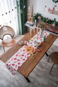 Detailed view of Christmas table runner with red candy cane patterns on festive wood table