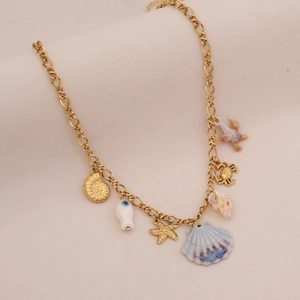 Dettaglio della collana oceano dorata con ciondoli a stella marina, conchiglia e granchio