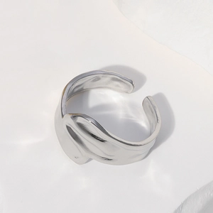 Irregular silver titanium steel open ring with sleek streamlined design on white rock