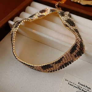 Detail of leopard print necklace with rhinestones and extension chain in jewelry box