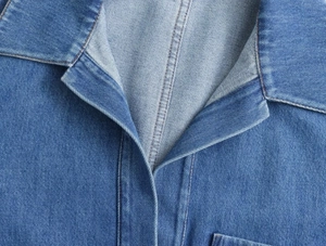 Detailansicht eines blauen Denim-Hemdkragens mit hochwertigen Nähten und Twill-Textur