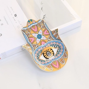 Detailed view of colorful Hamsa Hand ceramic jewelry trays with gold rim and evil eye motifs