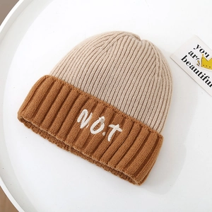 Detailed close-up of color-block knit beanie with white N.O.T embroidery on thick ribbed fabric